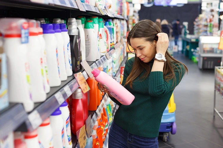 Femme choisit la lessive au supermarché pour laver les peluches