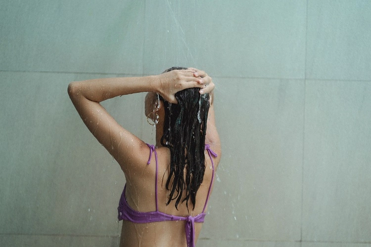 Femme lave ses cheveux avec du shampooing