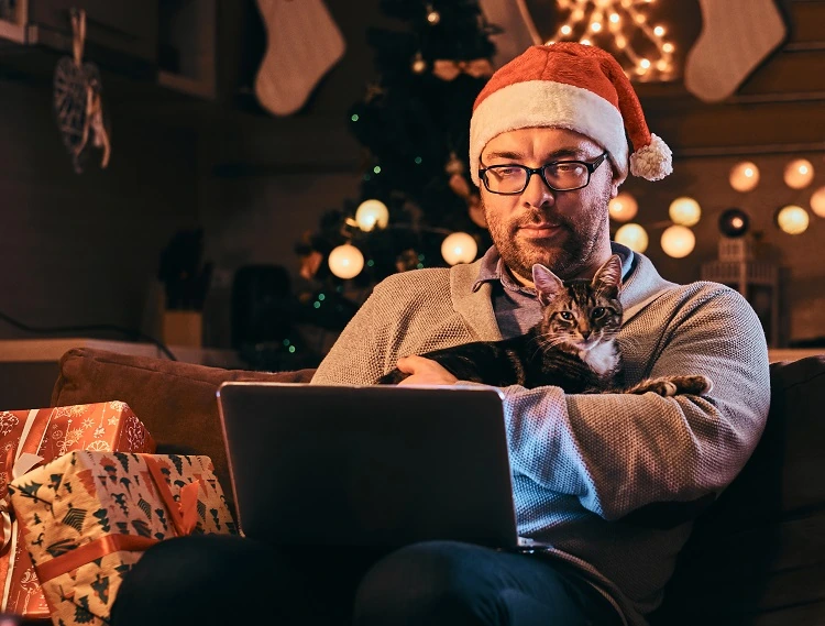 Homme avec chat regardent des films de Noël streaming