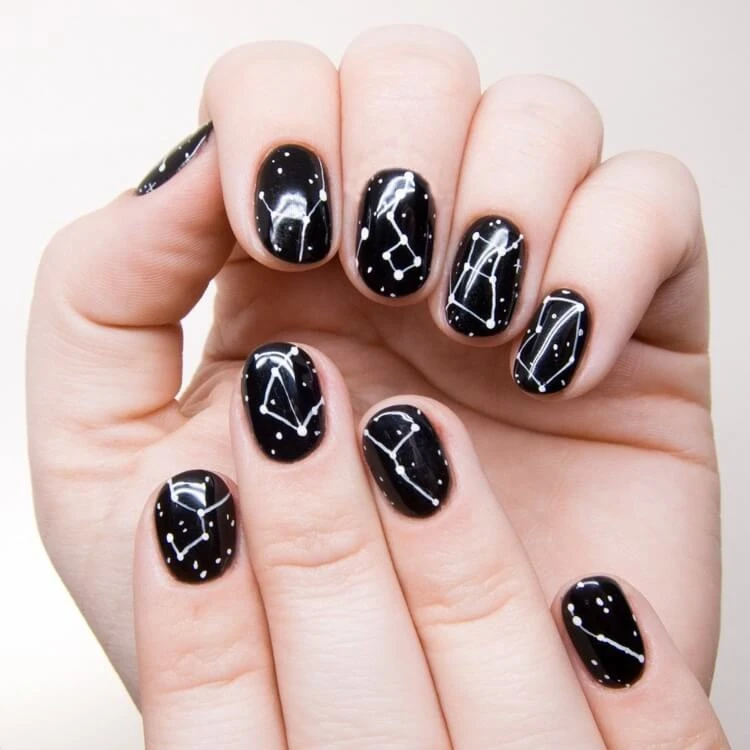 manucure astrologique pour Scorpion ongles courts noirs avec nail art constellations blanches