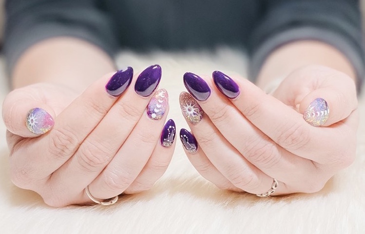 manucure astrologique stylée avec nail art planètes et constellations sur un vernis violet