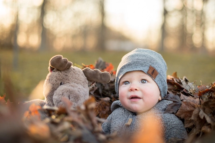 Petit bébé avec son jouet dehors automne