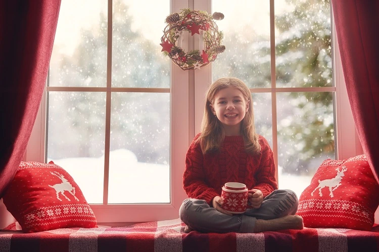 Petite fille devant une couronne de Noël pour vitre fait maison