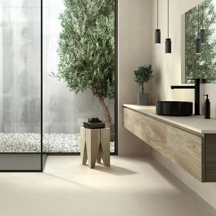 salle de bain de style biophilique meuble vasque en bois vue sur la cour intérieure avec arbre et galets blancs ambiance de relax