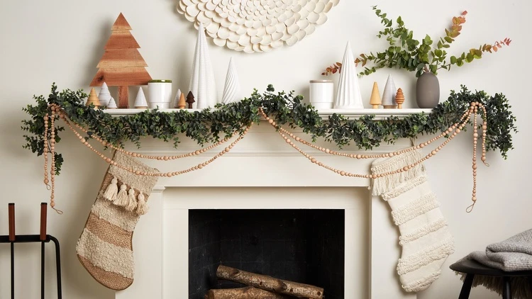 déco Noel manteau de cheminée scandinave hygge guirlande de verdure et perles en bois chaussettes tricot