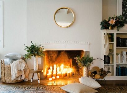 déco hygge pour Noel bougies allumées dans la cheminée coussins de sol plaid cozy