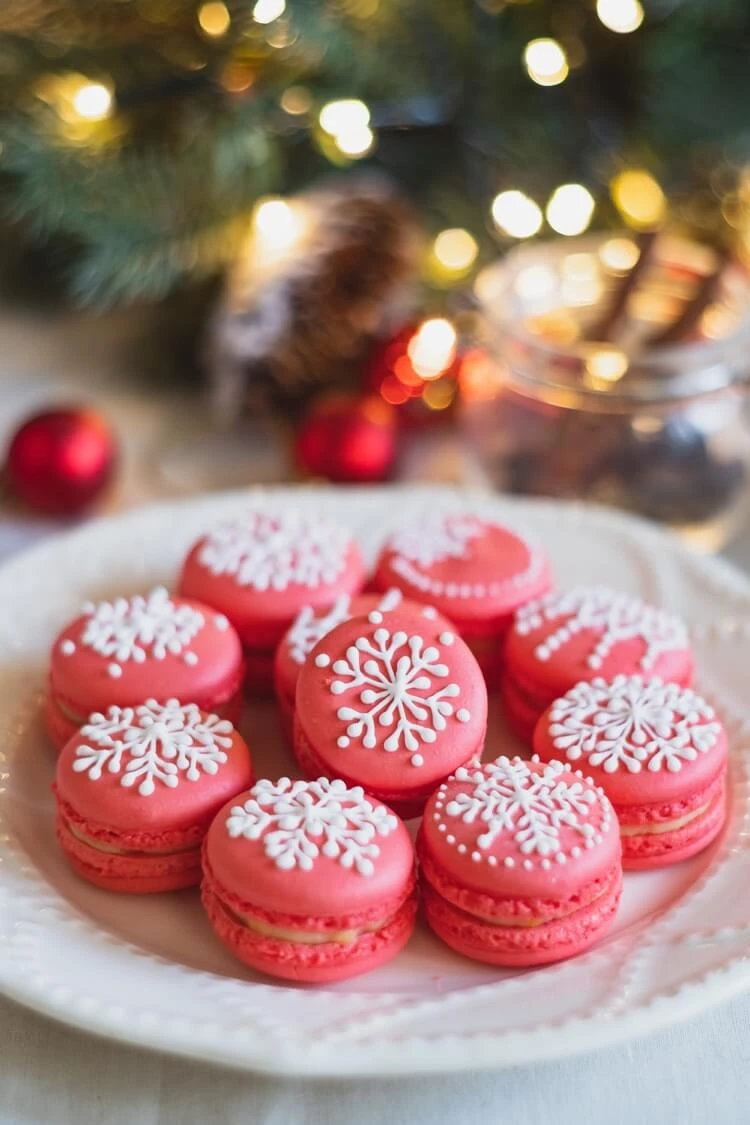 macarons rouges motifs flocons de neige au glacage blanc pour les fetes