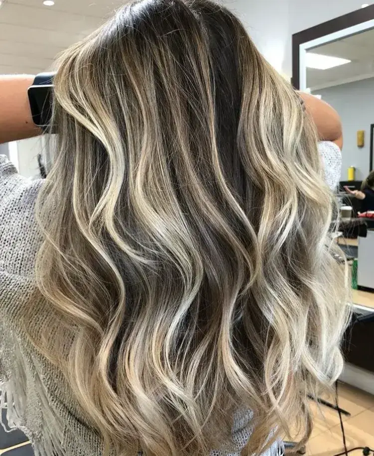 coloration balayage blond polaire sur brun coiffure brushing ondulé