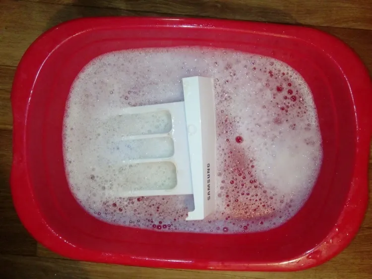 comment nettoyer bac à lessive laver eau courante tremper mélange vinaigre bicarbonate