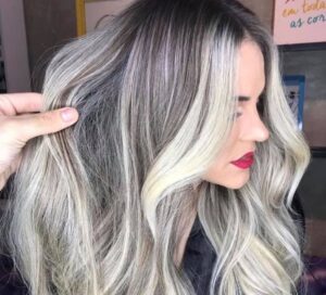 tendances capillaires balayage blond polaire sur brun cheveux longs ondulés