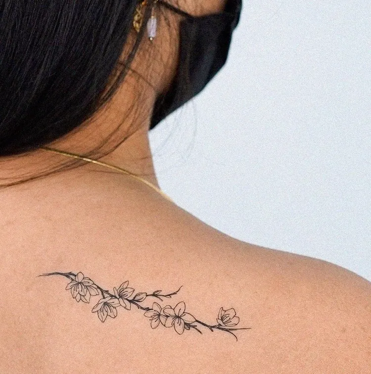 micro tatouage dos femme fleur minimaliste