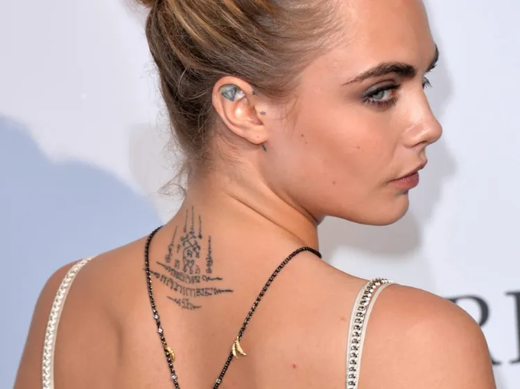 photos tatouage de star Cara Delevingne nuque yantra oreilles tatoués