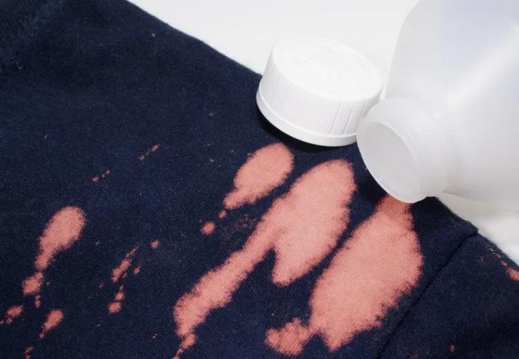Bleach stain to neutralize a black stain on a dark colored garment