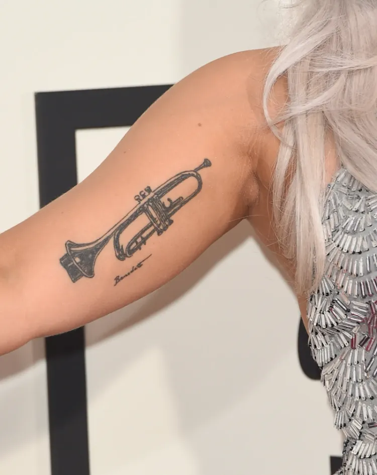 tatouage de star lady gaga trompette intérieur bras biceps musique