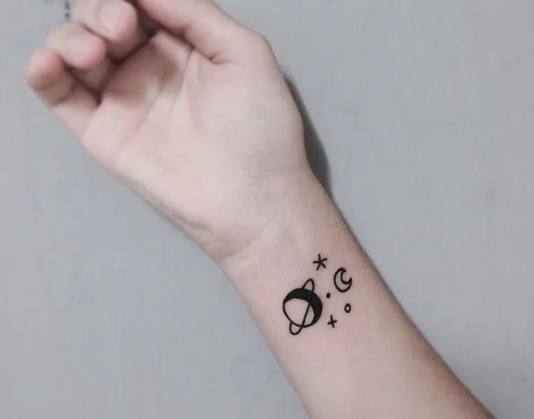 tatouage planètes étoiles style gribouillage poignet femme discret