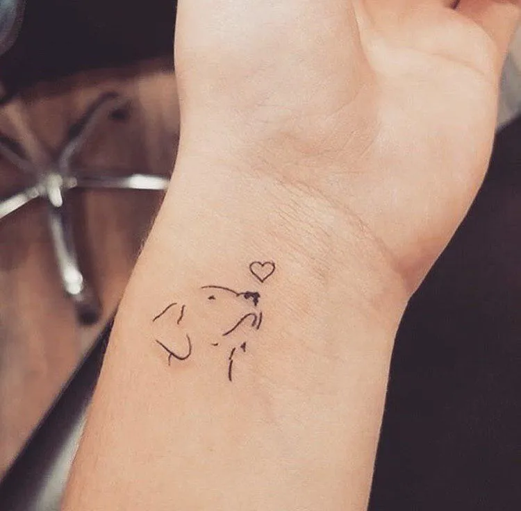 tatouage poignet femme style minimaliste contours chien compagnie