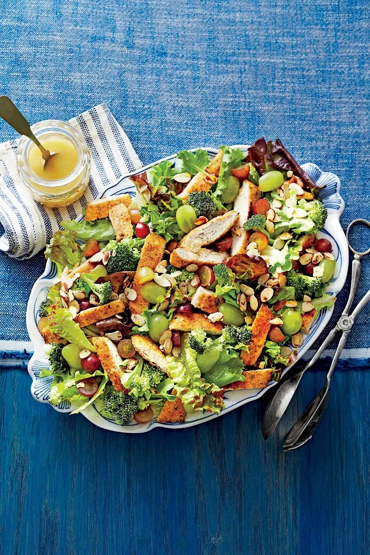 Fresh recipe with summer salad of breaded chicken and grapes, almonds and broccoli as a main course