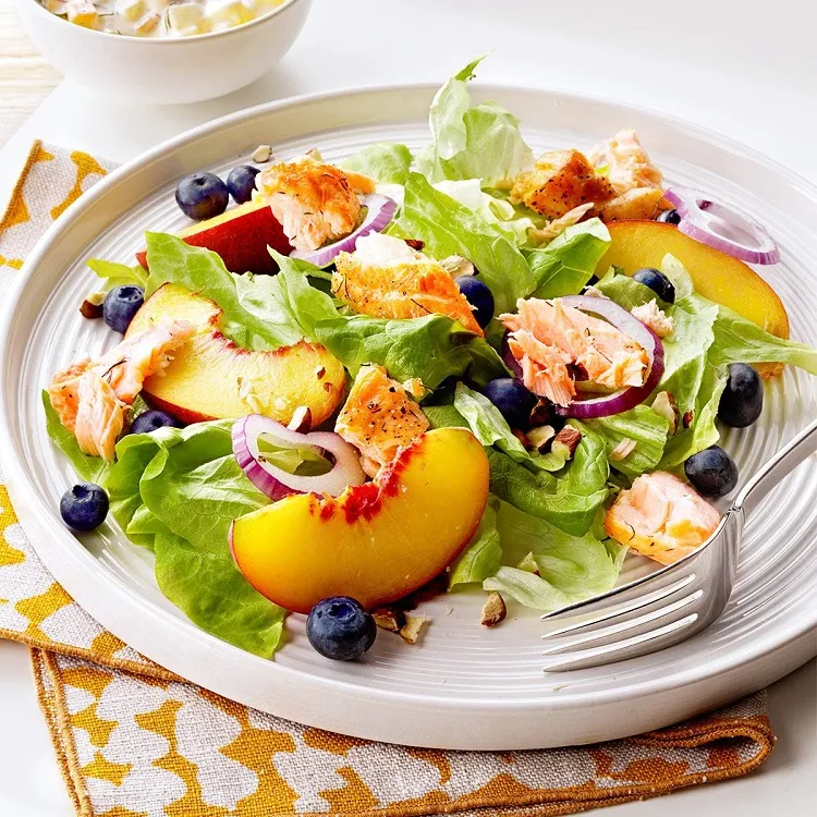 Summer salad main course with salmon, lettuce and peaches