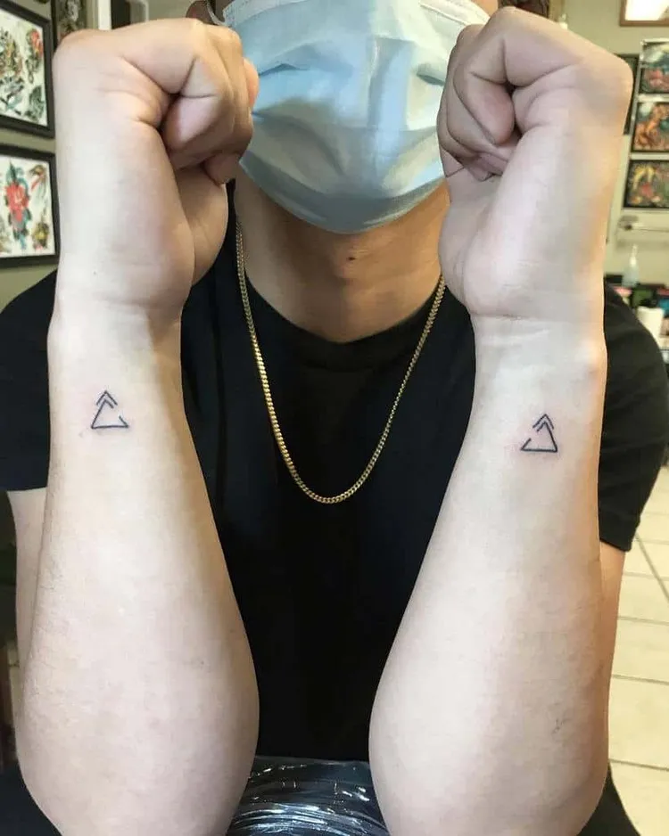petits tatouages discrets sur les poignets deux triangles homme