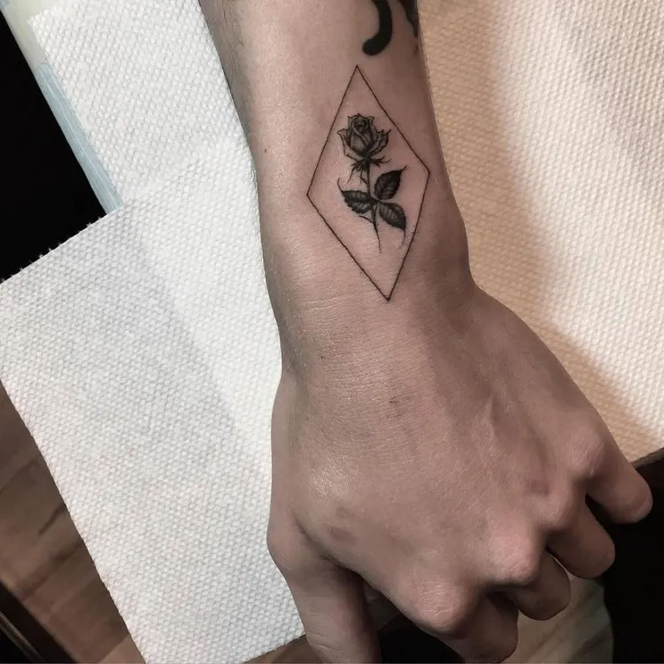 tatouage géométrique homme fleur de rose sur le bras