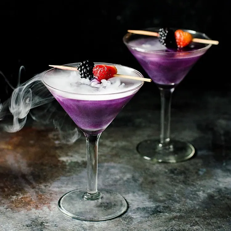Purple steaming Halloween cocktail with fruit