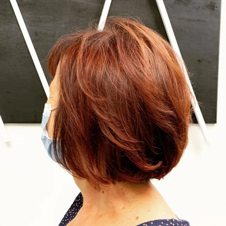 coloration rouge bordeaux femme 50 ans carré court frange effet coiffure anti âge
