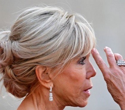 idée coiffure anti âge femme 60 ans le chignon haut et bouclé banane de brigitte macron coupe avec frange rideau pour se rajeunir