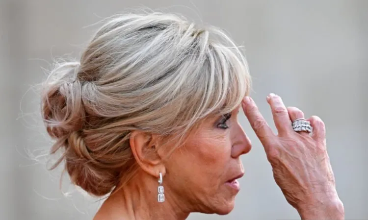 le chignon de brigitte macron est la nouvelle coiffure anti âge de l'été 2023 femme 60 70 ans chignon haut bouclé frange rideau