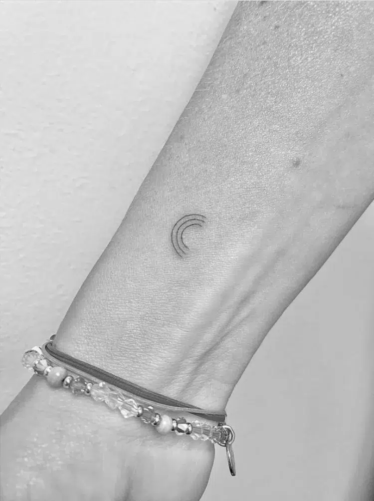 petit tatouage discret pour femme sur le poignet tatouage arc en ciel en noir et blanc