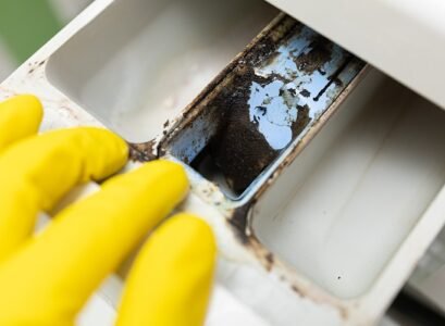 yellow glove hand check, open washing machine container, drawer for detergent and conditioner, detect of dirt and mold