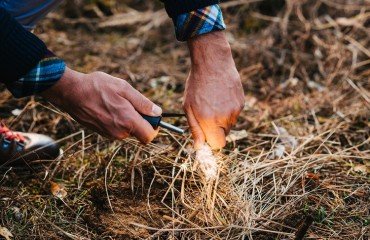 a man makes a fire with a flint