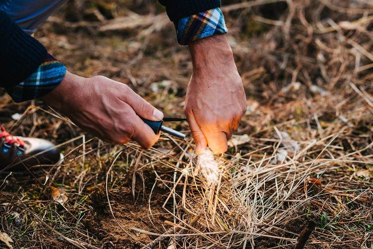 a man makes a fire with a flint