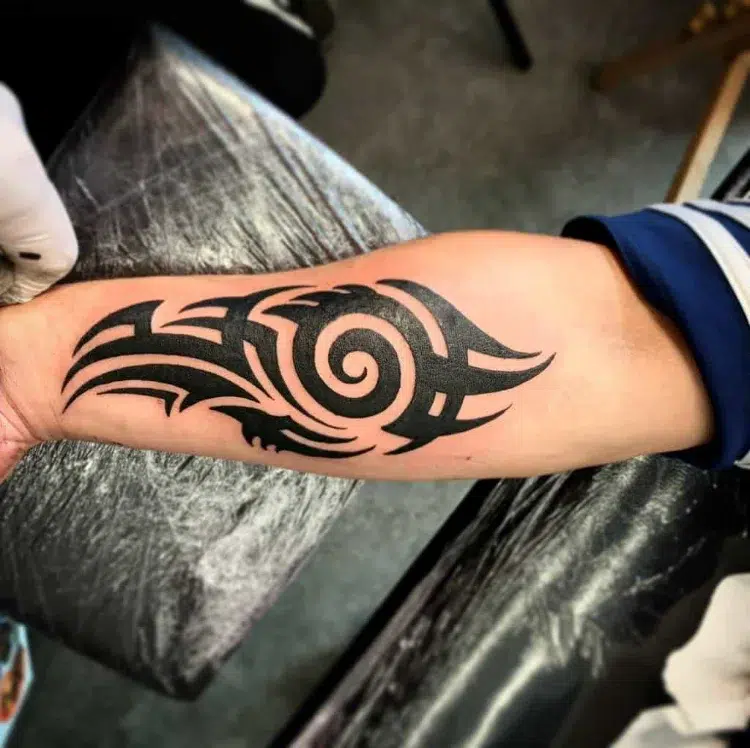 tatouage tribal simple lignes épaisses noires entrelacs symboliques avant bras