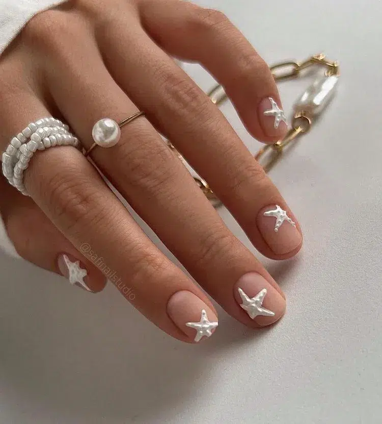 manucure minimaliste nude blanche étoile de mer des bijoux avec perles