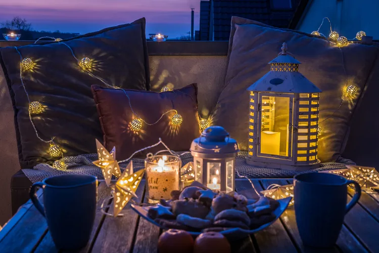 coussins décoratifs, guirlandes lumineuses et bougies pour un coin romantique