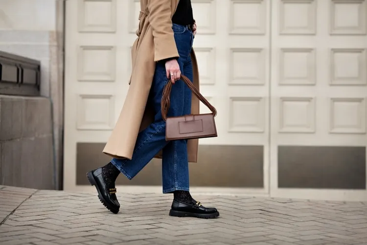 tenue d'automne composée de mocassins, de jean et d'un long camel coat