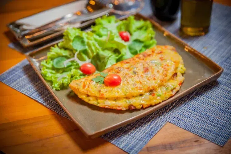 omelette aux légumes garnie de salade verte et tomates cerise