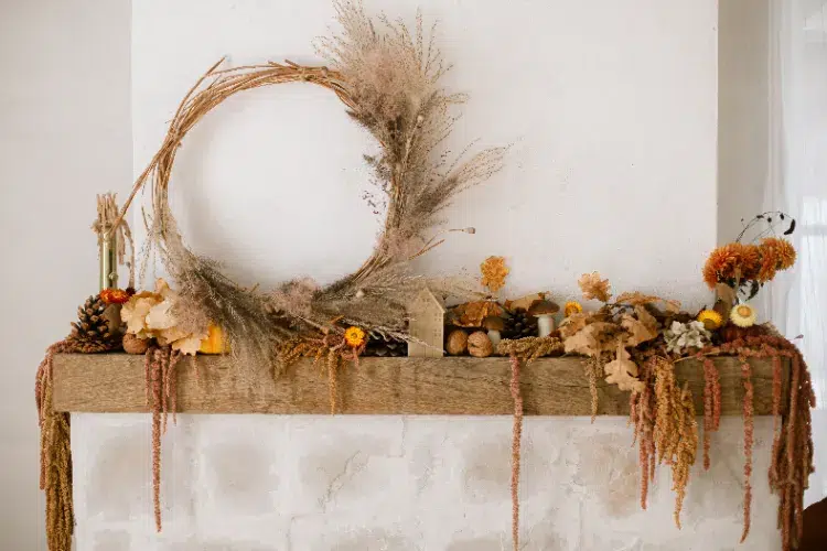 décoration d'automne sur le manteau de la cheminée avec des fleurs séchées et une couronne de pampa