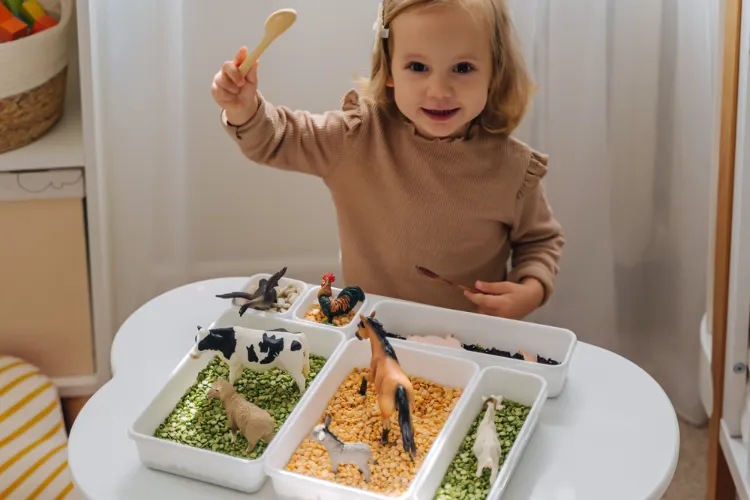 une boîte sensorielle avec des produits alimentaires et des figurines d'animaux