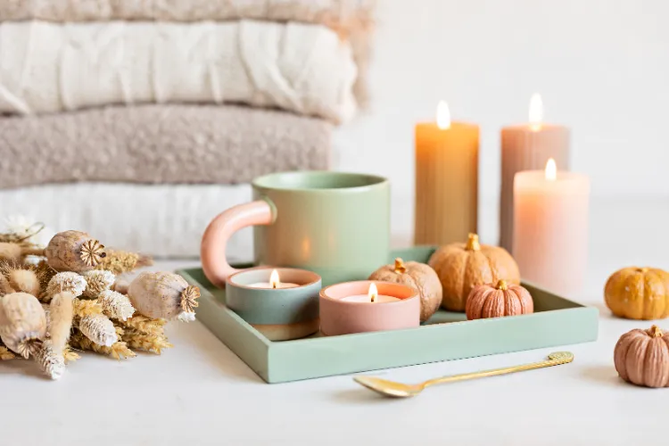 une idée de centre de table automnal aux nuances pastel avec des courges et des bougies