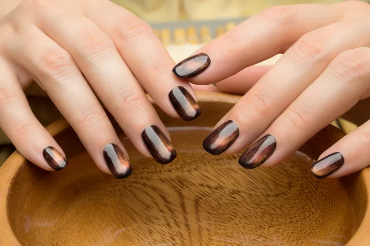 une idée de nail art oeil de chat sur des ongles marron pour l'automne 2024