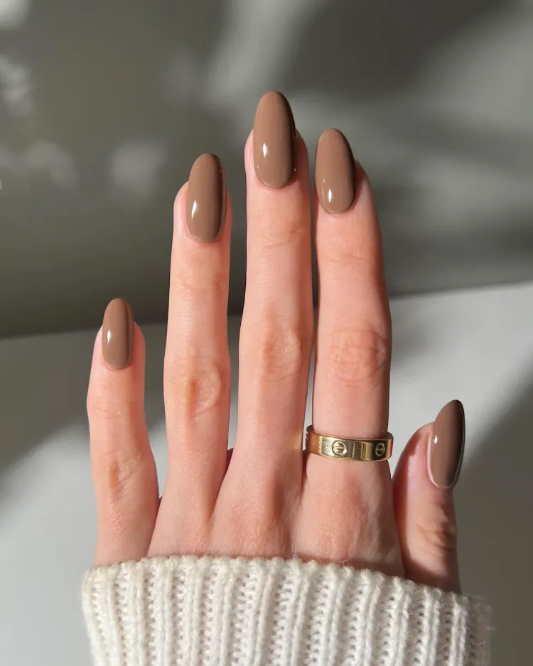 une jolie manucure en amande avec un vernis marron nougat