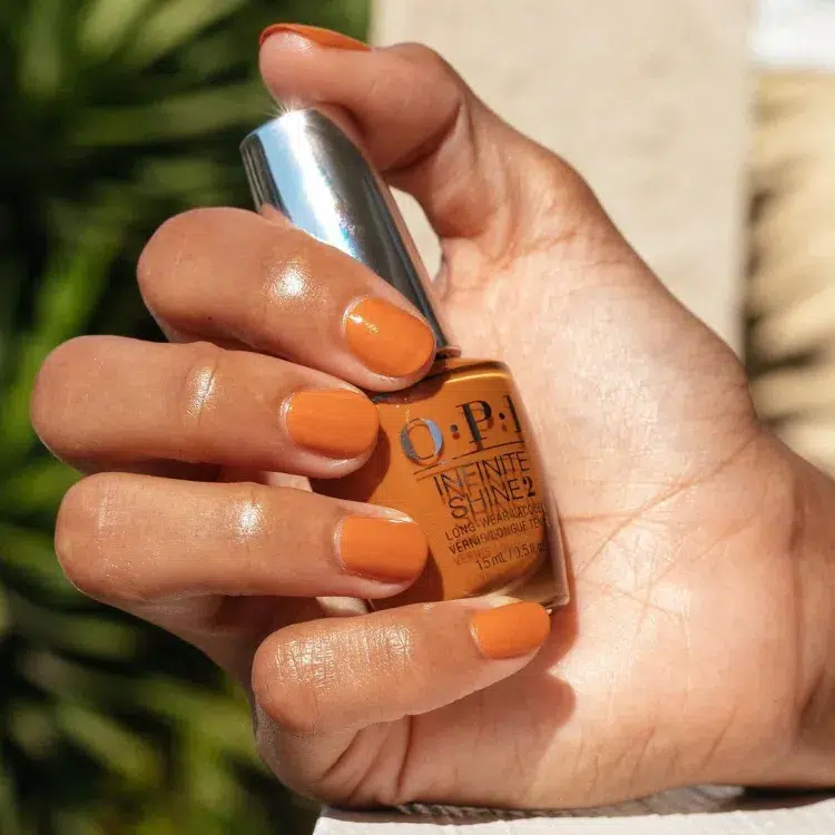 une jolie manucure en orange brûlé sur des ongles courts pour l'automne 2024