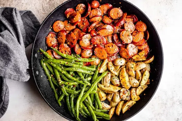 de la saucisse fumée garnie de pommes de terre et haricots verts