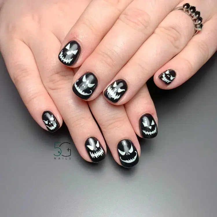 jack o' lantern nail art sur des ongles courts noirs