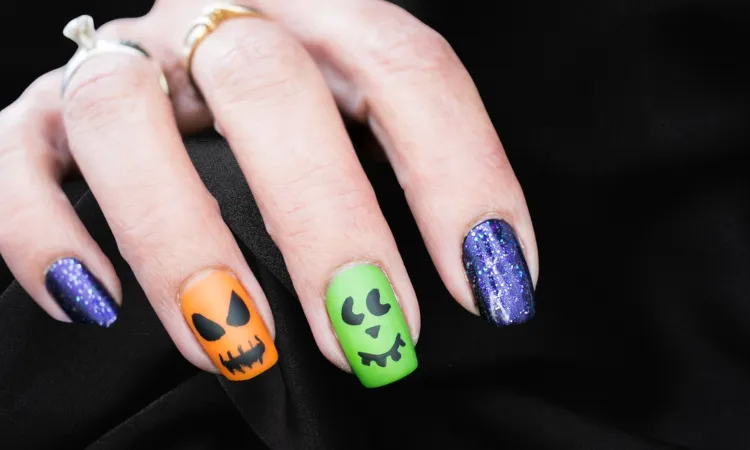 jack o'lantern nail art avec des vernis aux couleurs vives