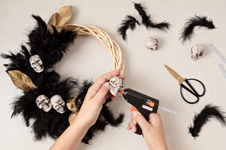 décorer la couronne d'halloween avec des plumes noires et des figurines de crânes