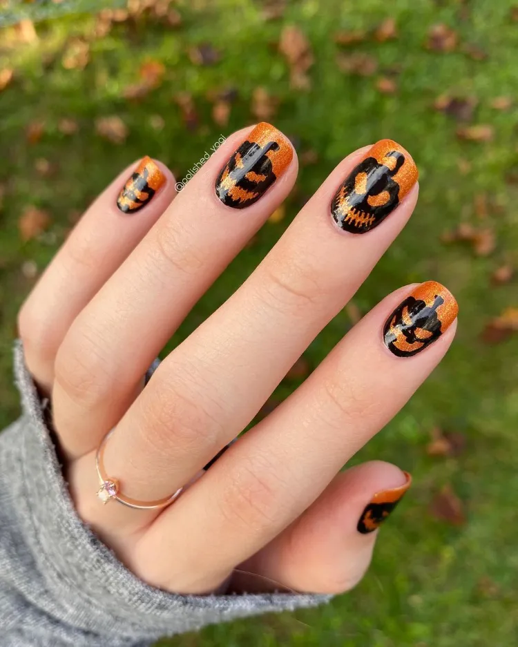 des ongles en noir et orange avec le motif de jack o' lantern