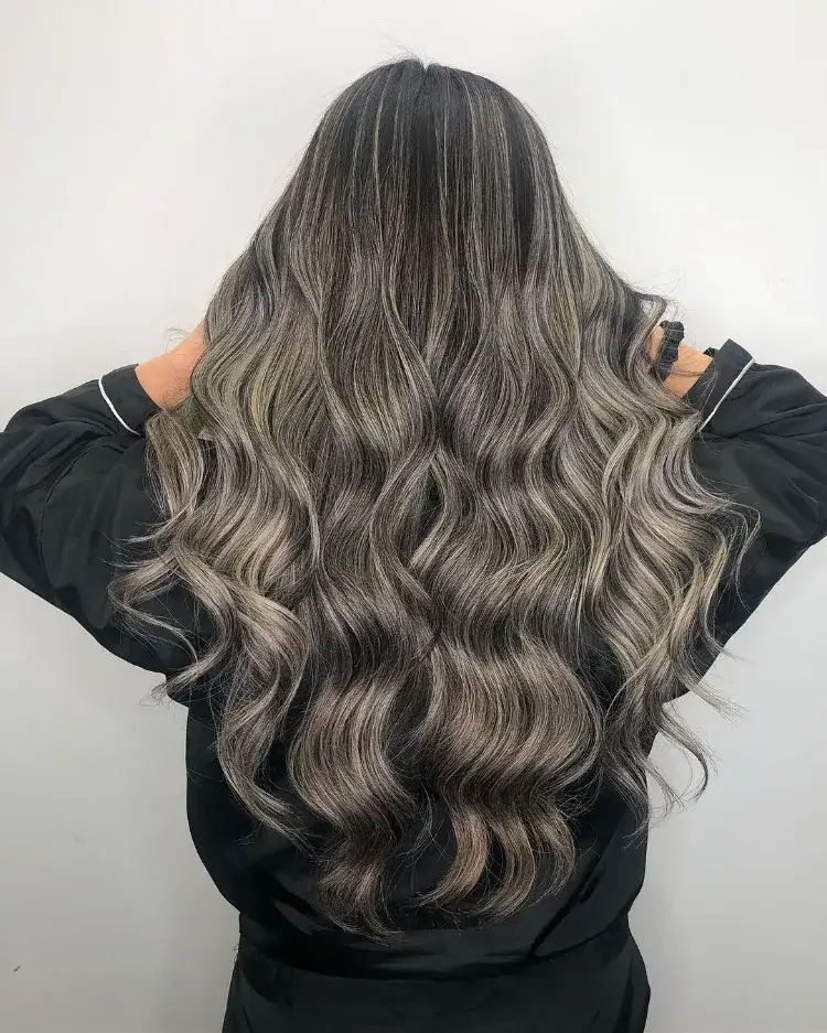 un balayage blond cendré et des babylights sur une base châtain foncé