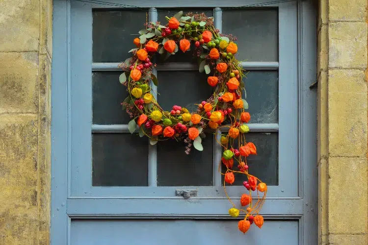 une couronne de physalis baies rouges et feuilles en tant que décoration de porte automnale